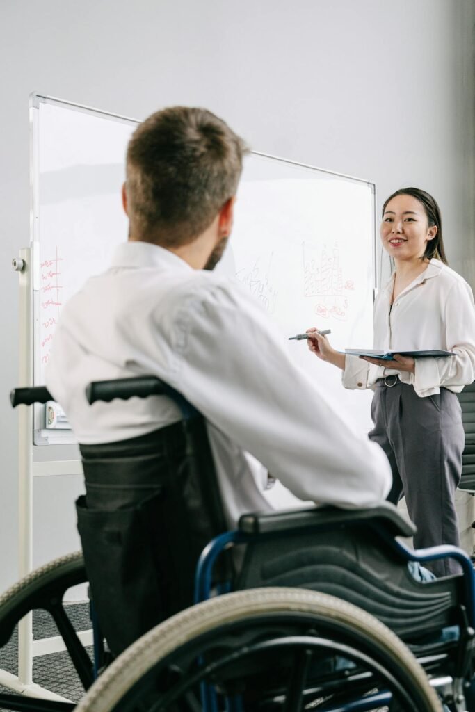 Professional woman presenting digital marketing strategy on laptop to diverse team members in bright modern office with engagement metrics visible on screen
