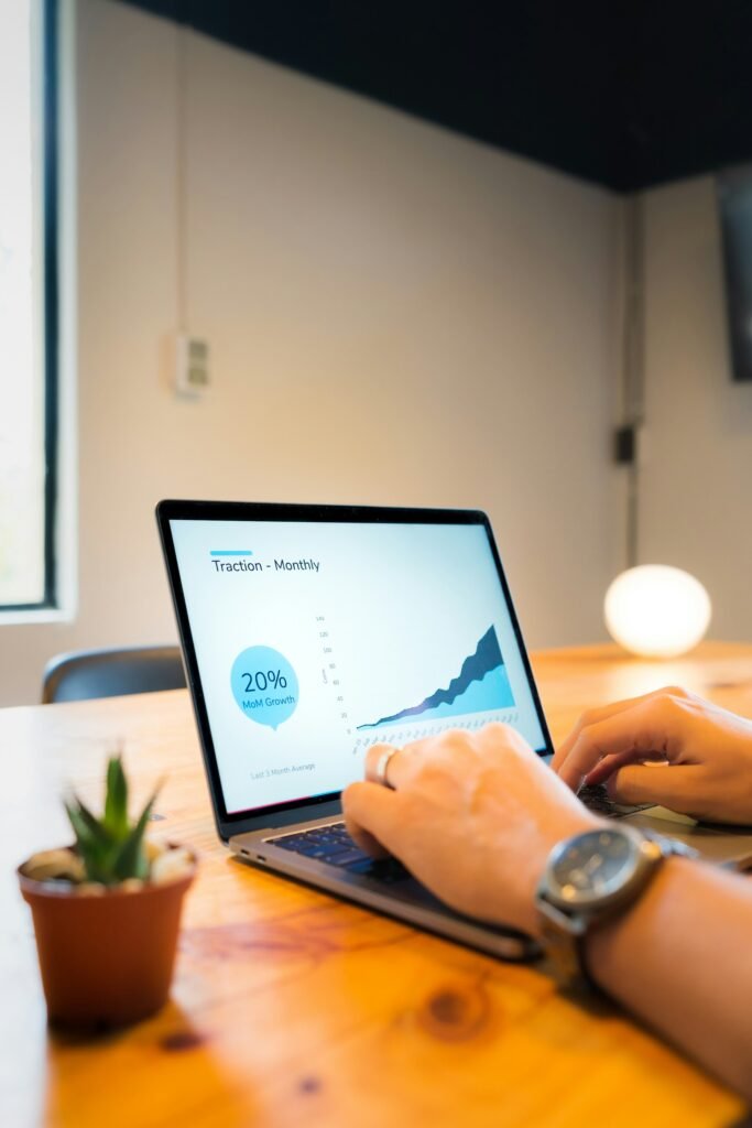 Professional data analytics visualization on laptop screen displaying colorful bar charts and growth metrics for SEO performance tracking in modern office environment
