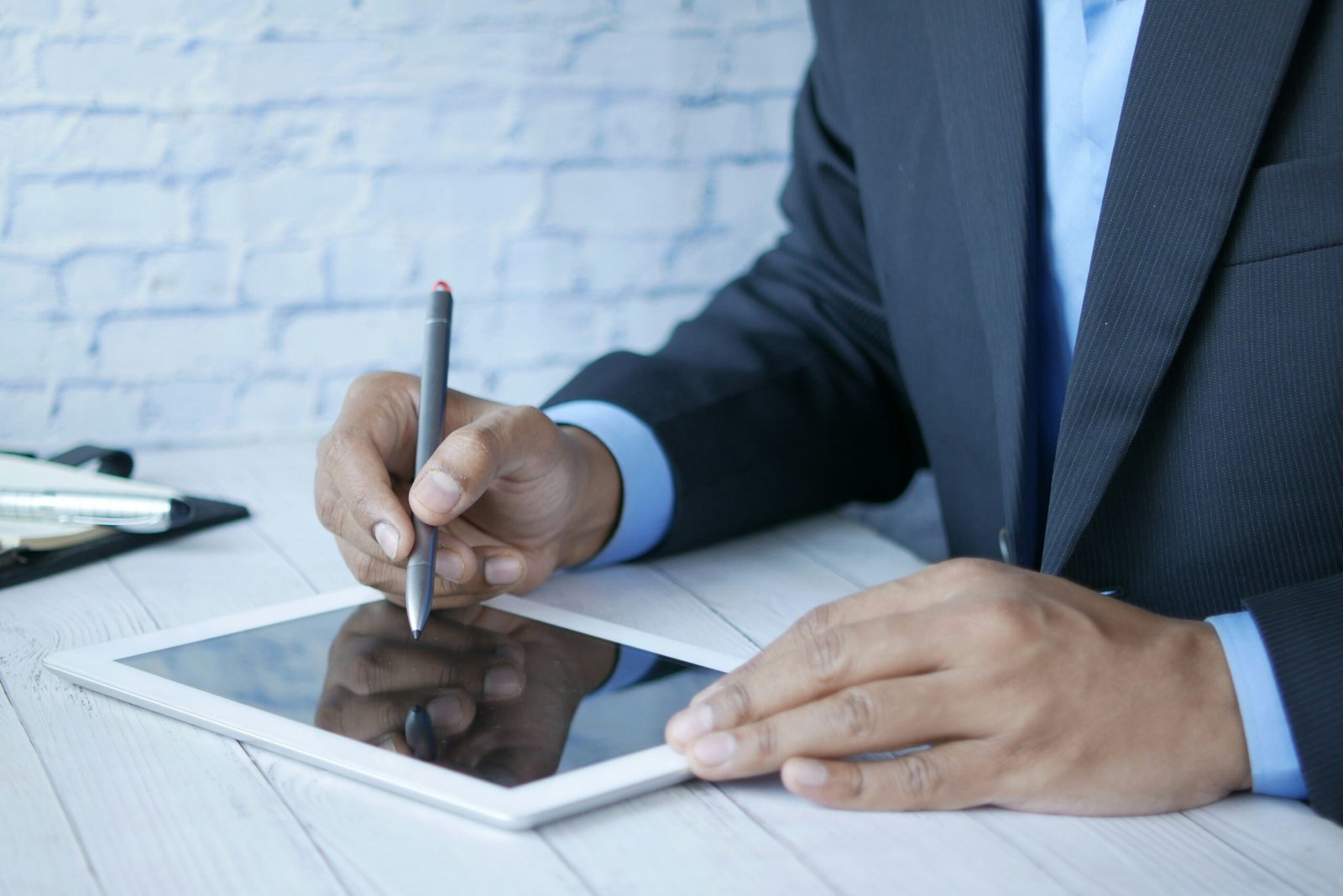 Real estate agent using tablet device to manage property listings and upload images to MLS platform