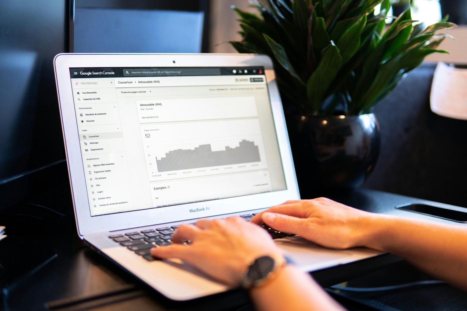 Overhead view of laptop displaying website analytics with coffee cup and notepad on wooden desk